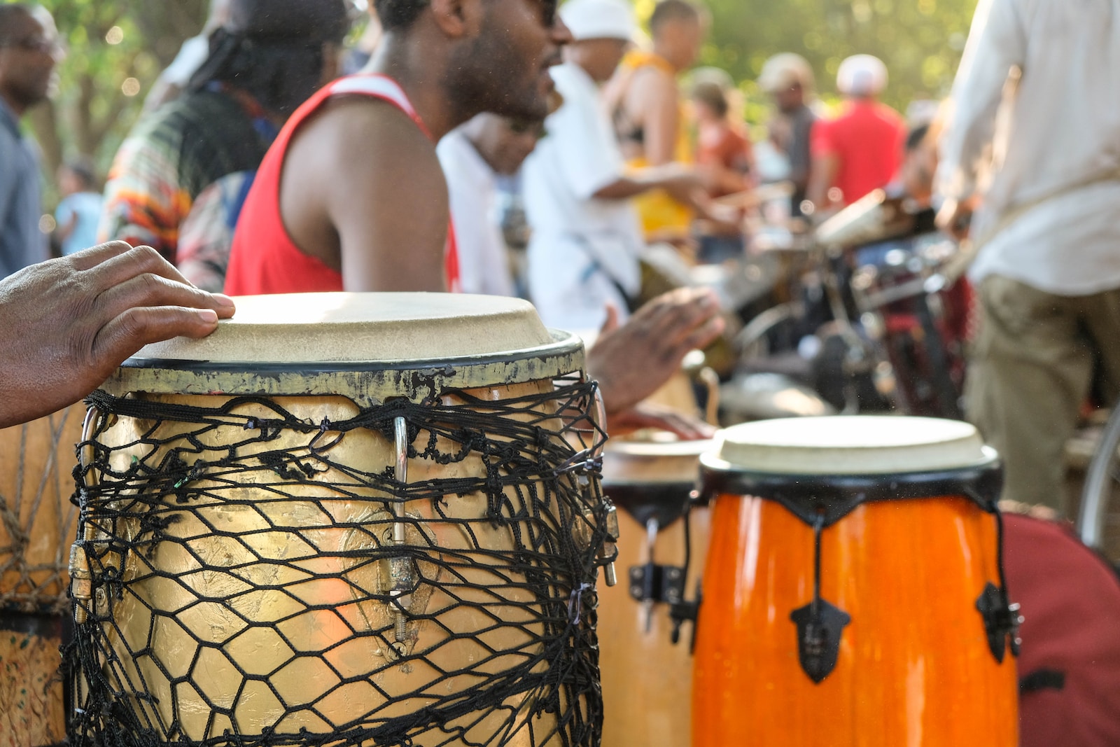 a group of people playing african percussion instruments in a park