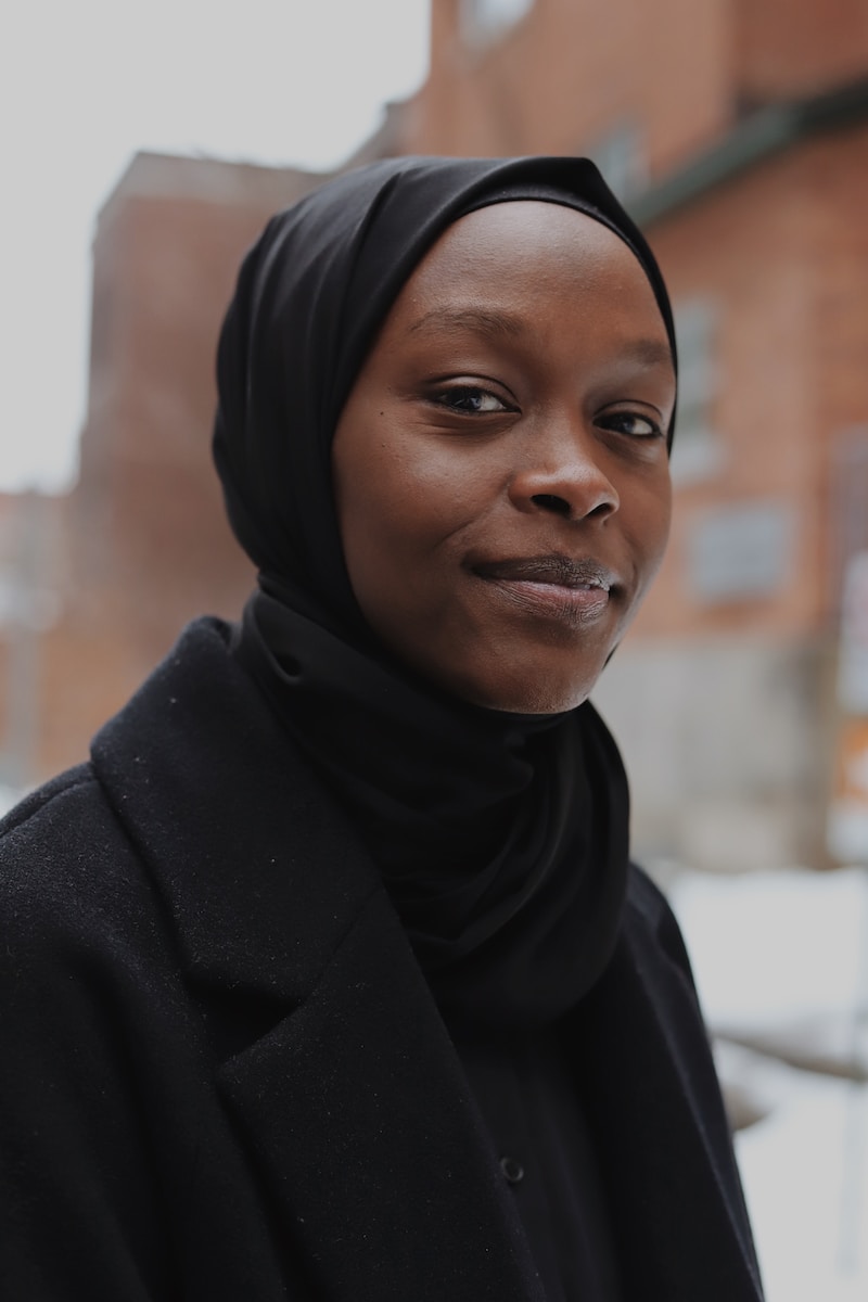young black woman in black hijab and black coat